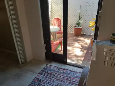 an open door with a red chair and a table at The Fairway in Cape Town