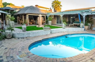a swimming pool in a backyard with a gazebo at De Helling Self Catering in Brackenfell