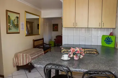 a kitchen with a table with flowers on it at De Helling Self Catering in Brackenfell