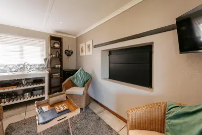 a living room with a flat screen tv on the wall at Dennehof Farm Guesthouse in Villiersdorp