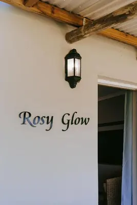 a sign for a rosy grow sign on a wall at Dennehof Farm Guesthouse in Villiersdorp