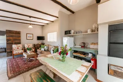 a living room with a table and a couch at Dennehof Farm Guesthouse in Villiersdorp
