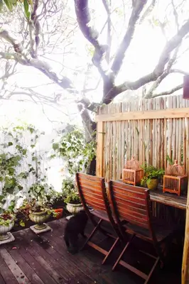 a wooden deck with a bench and a bird cage at The Birdhouse in Cape Town