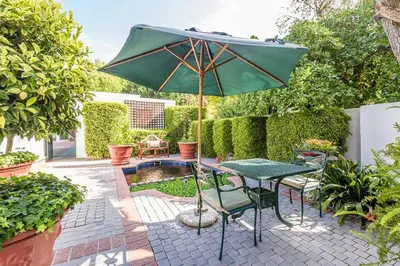 a patio with a table and an umbrella at Van der Stel Manor in Stellenbosch