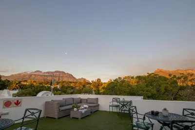 a patio with a couch and chairs and a table at Van der Stel Manor in Stellenbosch