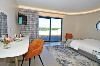 a bedroom with a bed and a table and chairs at 7 on Marine in Hermanus