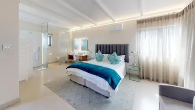 a bedroom with a large bed with blue pillows at 7 on Marine in Hermanus