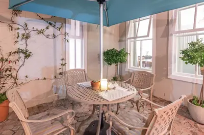 a table and chairs with an umbrella in a room at Waterstone Lodge in Somerset West