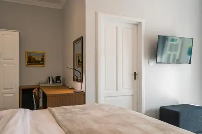 a bedroom with a bed and a desk and a television at Waterstone Lodge in Somerset West