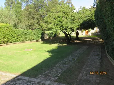 a garden with trees and a brick path at Town and Country in Caledon