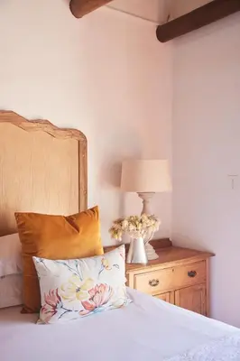 a bed with a pillow and a lamp on a night stand at Klein Waterval Riverside Lodge in Franschhoek