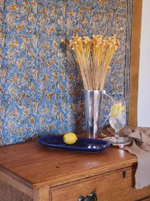 a table with a vase and a plate of food at Klein Waterval Riverside Lodge in Franschhoek