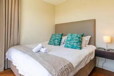a bedroom with a bed with two stuffed animals on it at da Heim Guest House in Cape Town
