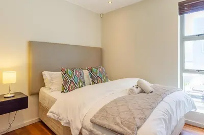 a bedroom with a bed with a teddy bear on it at da Heim Guest House in Cape Town