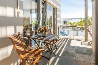 a patio with a table and chairs on a balcony at da Heim Guest House in Cape Town