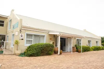 a building with a brick driveway in front of it at Fijnbos Manor in Bettyʼs Bay
