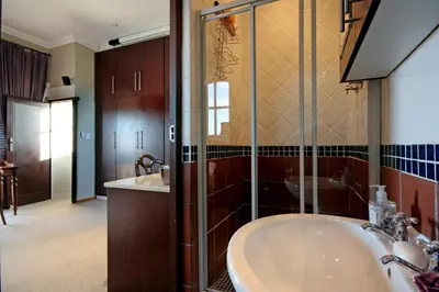 a bathroom with a tub and a shower and a sink at A Smart Stay Apartments in Somerset West