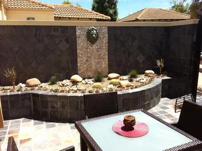 a patio with a table with a hat on it at A Smart Stay Apartments in Somerset West