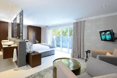 a bedroom with a bed and a living room at Grand Blue D in Cape Town