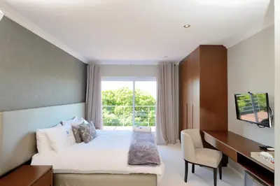 a bedroom with a bed and a desk and a window at Grand Blue D in Cape Town