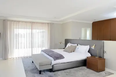 a bedroom with a bed and a large window at Grand Blue D in Cape Town