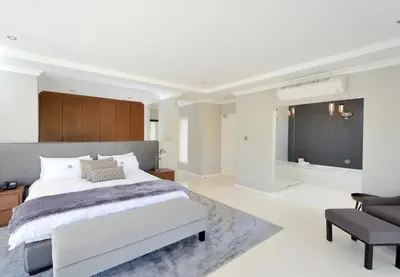 a bedroom with a large bed and a chair at Grand Blue D in Cape Town