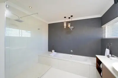 a white bathroom with a tub and a sink at Grand Blue D in Cape Town