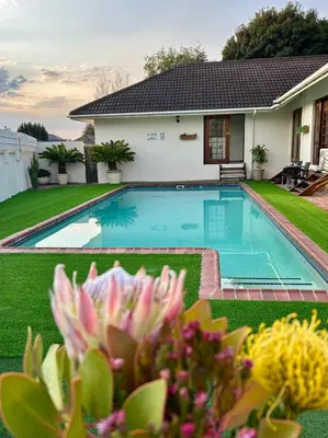 a swimming pool in front of a house at Dolliwarie Guesthouse in Panorama