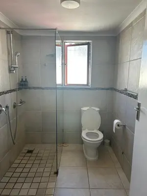 a bathroom with a toilet and a glass shower at Dolliwarie Guesthouse in Panorama