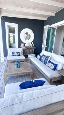 a living room with two couches and a mirror at Kallistes Misty Shores Cottage in Bettyʼs Bay