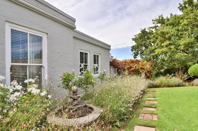 a house with a garden in front of it at Three Oaks in Durbanville