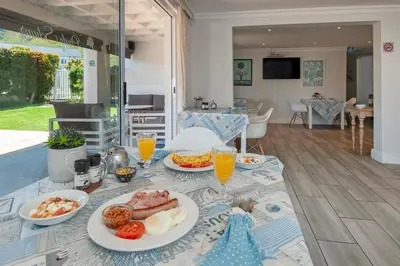 a table with plates of food on top of it at Oude Schuur Boutique Guesthouse in Hermanus