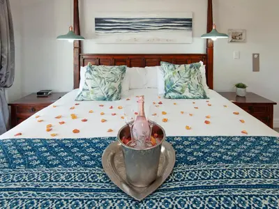 a bed with a bowl with a bottle on it at Oude Schuur Boutique Guesthouse in Hermanus