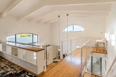 a white room with a staircase and two windows at The Ivy Apartments Franschhoek in Franschhoek
