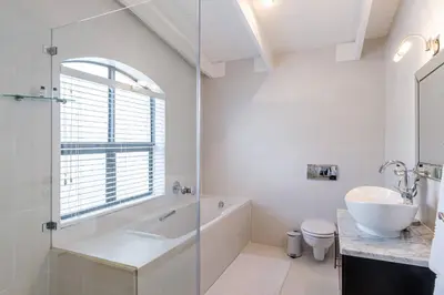 a bathroom with a tub and a sink and a toilet at The Ivy Apartments Franschhoek in Franschhoek