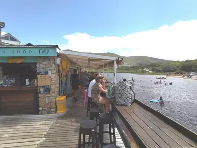 a group of people sitting on a dock near the water at Matshana Lodge in Hermanus