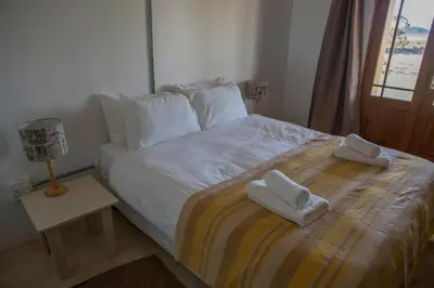 a bedroom with a bed with two towels on it at Windfall Wine Farm in Robertson