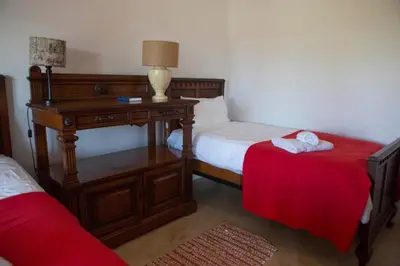 a bedroom with two beds and a table with a lamp at Windfall Wine Farm in Robertson