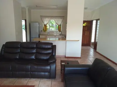 a living room with a couch and a kitchen at Getaway Self-Catering Tyger Valley in Durbanville
