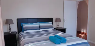 a bed with two blue pillows on top of it at Getaway Self-Catering Tyger Valley in Durbanville