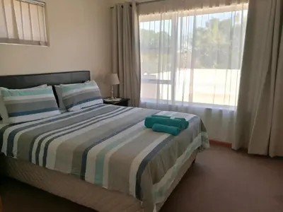 a bedroom with a bed with a large window at Getaway Self-Catering Tyger Valley in Durbanville