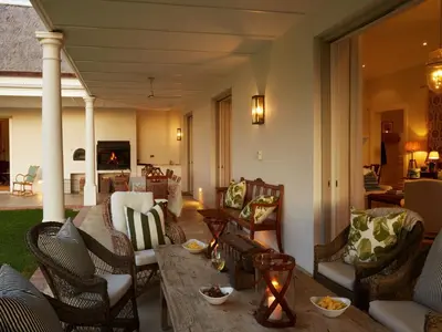 a living room with chairs and a wooden table at La Cotte House in Franschhoek