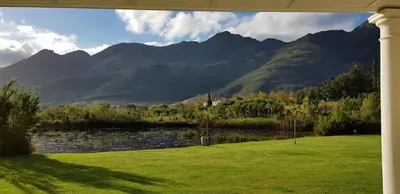 a view of a lake with mountains in the background at La Cotte House in Franschhoek