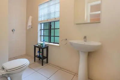 a bathroom with a toilet and a sink and a window at Elgin Country Lodge in Elgin