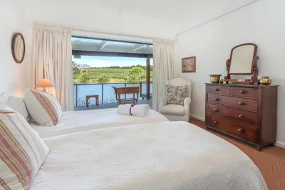 a bedroom with a large bed with a dresser and a window at Elgin Country Lodge in Elgin