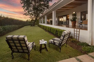two chairs and a table in the yard of a house at Elgin Country Lodge in Elgin