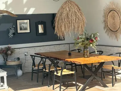 a dining room with a wooden table and chairs at Southern Cross Guesthouse in Somerset West