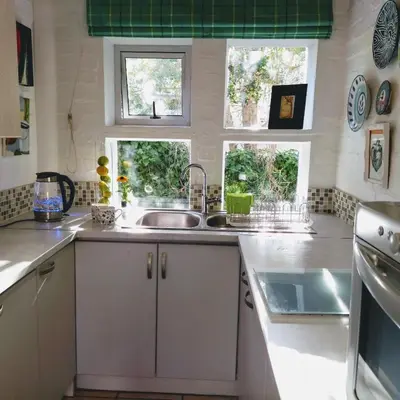 a kitchen with a sink and two windows at Festina Lente in Onrus in Hermanus
