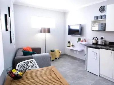 a small living room with a couch and a kitchen at Studio on Bourdeaux in Panorama