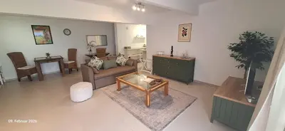 a living room with a couch and a table at Agape Apartments in Somerset West